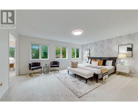 A bedroom with a large bed, a bench, and a rug in the center.