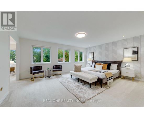 A bedroom with a large bed, a bench, and a rug in the center.