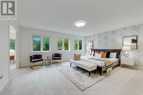 A bedroom with a large bed, a bench, and a rug in the center.