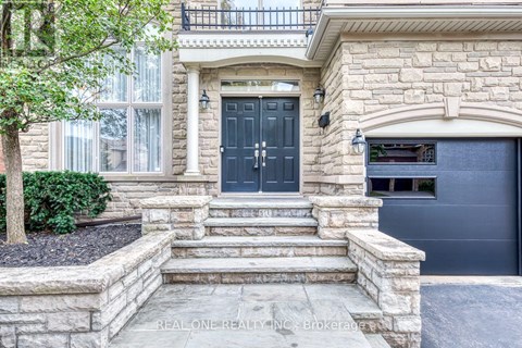 A house with a black front door and a stone wall.
