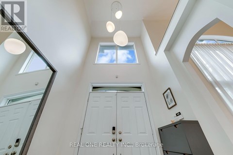 A white door is in the middle of a hallway with a skylight above it.