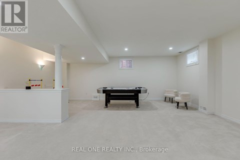A room with a pool table and chairs.