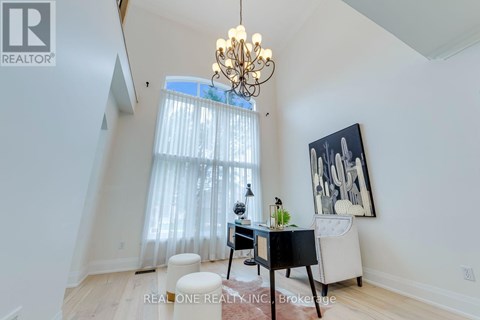 A room with a desk, chair, and a chandelier.