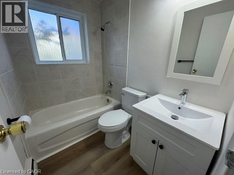 A bathroom with a white toilet, sink, and bathtub.