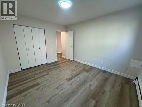 A room with wooden flooring and white walls.