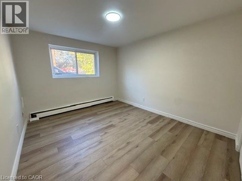 A room with a window and wooden flooring.