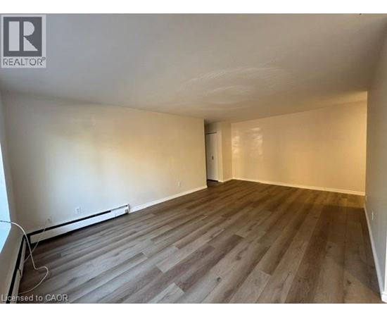 A room with wooden flooring and white walls.