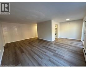 A room with wooden flooring and white walls.