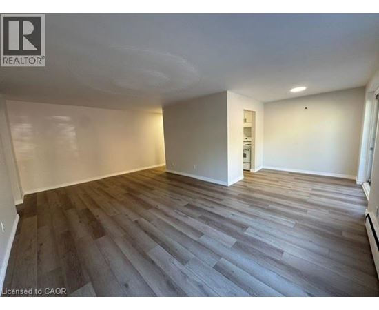 A room with wooden flooring and white walls.