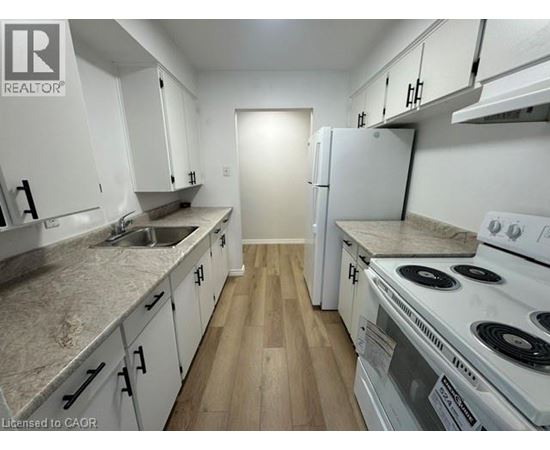 A kitchen with white appliances and cabinets.