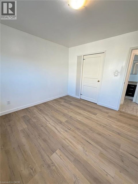 A room with wooden flooring and a white door.