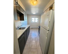 A kitchen with a white fridge and a window.