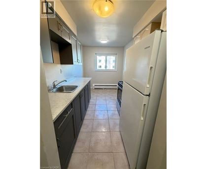 A kitchen with a white fridge and a window.