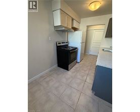 A kitchen with a black stove top oven and a white refrigerator.