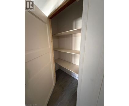 Empty pantry with white walls and shelves.