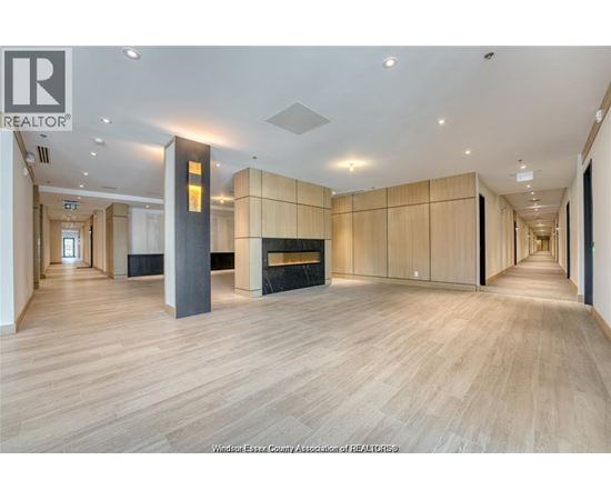 A spacious room with wooden floors and a fireplace.
