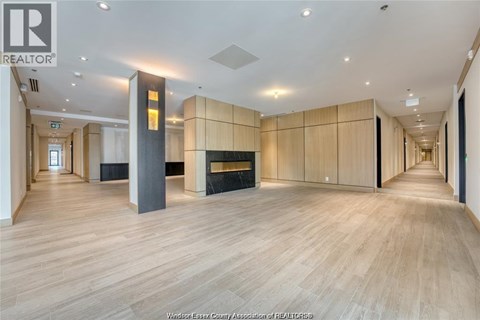 A spacious room with wooden floors and a fireplace.