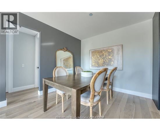 A dining room with a wooden table and chairs.
