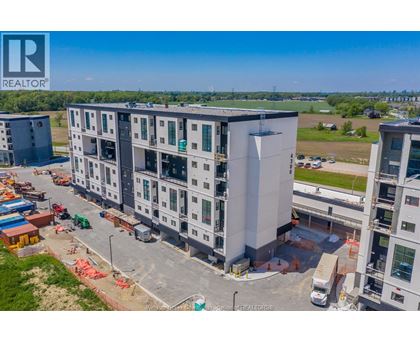 A large building under construction with a REALTOR® logo in the corner.