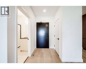 A hallway with a black door and white walls.