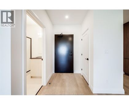 A hallway with a black door and white walls.