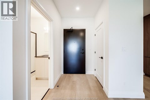 A hallway with a black door and white walls.