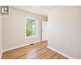 A room with a window and a door is empty and waiting to be furnished.