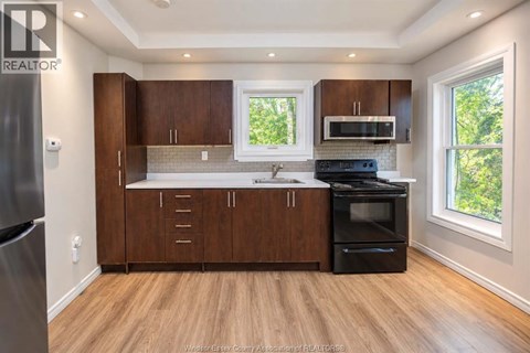 A kitchen with wooden cabinets and a black stove top oven.