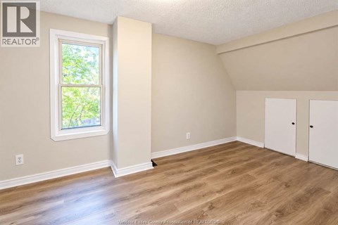 A room with a window and wooden flooring.