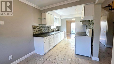 A kitchen with white cabinets and a black countertop.