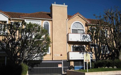 A large beige building with a black gate in front.