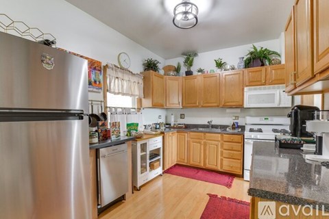 A kitchen with wooden cabinets and a stainless steel refrigerator.
