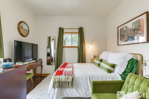 A bedroom with a large bed and a television.