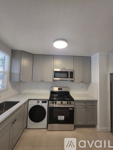 A kitchen with a washing machine and a stove top.