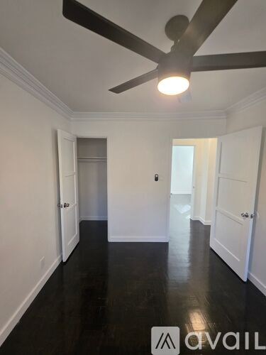 A room with a ceiling fan and black flooring.