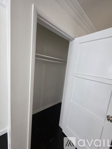 A white door is open to a dark hallway.
