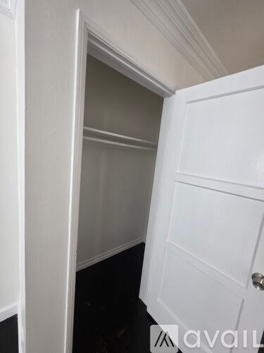 A white door is open to a dark hallway.