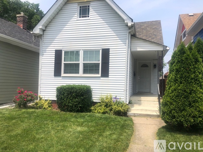 A house with a white siding and a grey door is for sale.