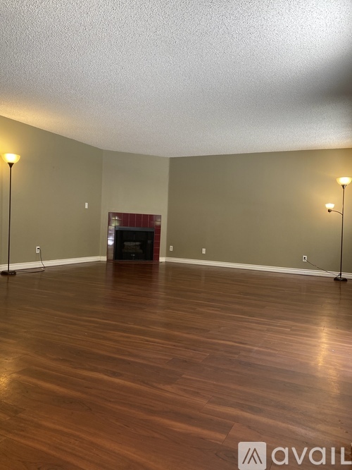 A room with wooden floors and two lamps on either side.
