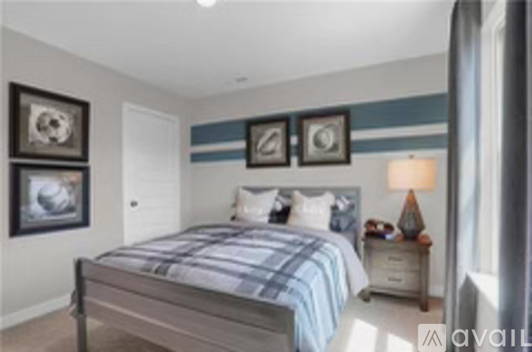 A bedroom with a bed, nightstand, and pictures on the wall.