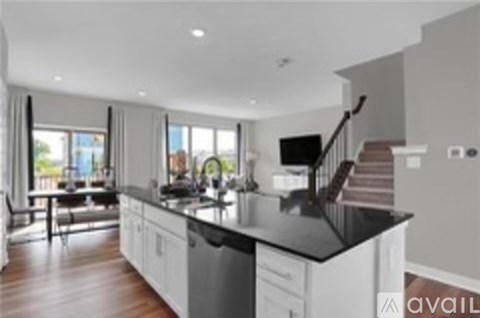 A modern kitchen with a black countertop and white cabinets.