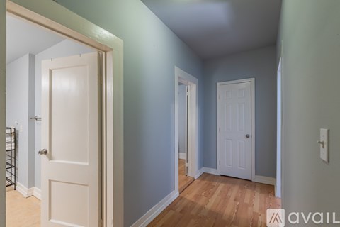 A hallway with two doors and a wooden floor.