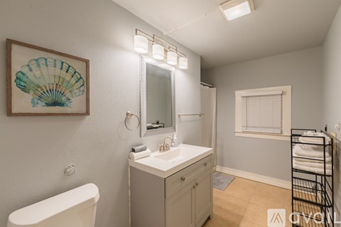 A white bathroom with a white tub and sink.