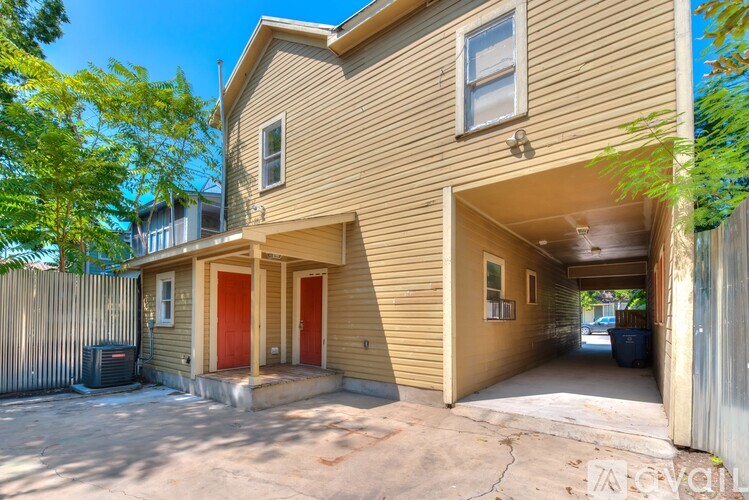 A tan house with a red door and a garage.