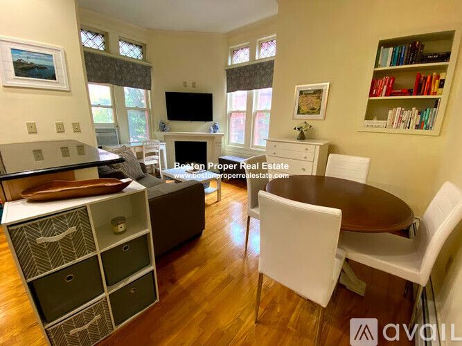 A living room with a brown table and white chairs.