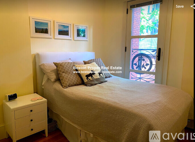 A bedroom with a bed, nightstand, and pictures on the wall.
