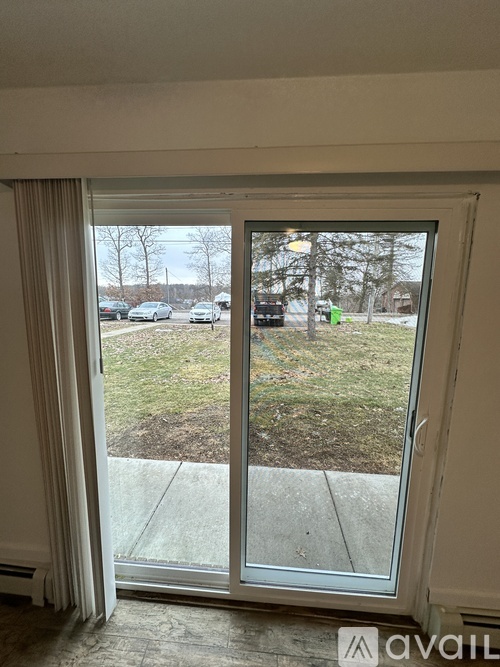 A view of a parking lot through a sliding glass door.