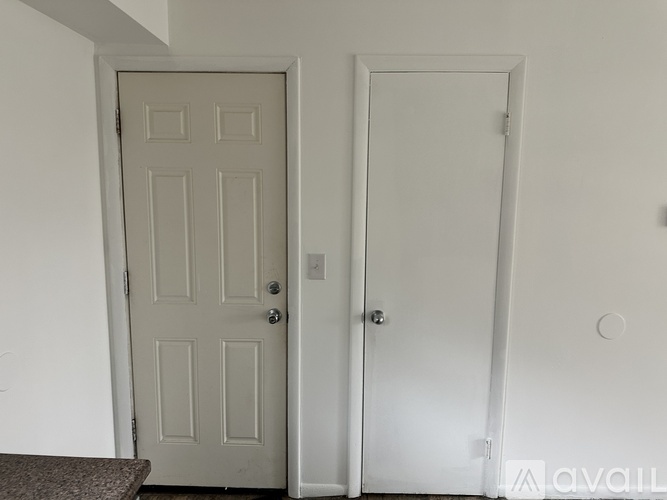 Two doors in a room with one door closed and the other door open.