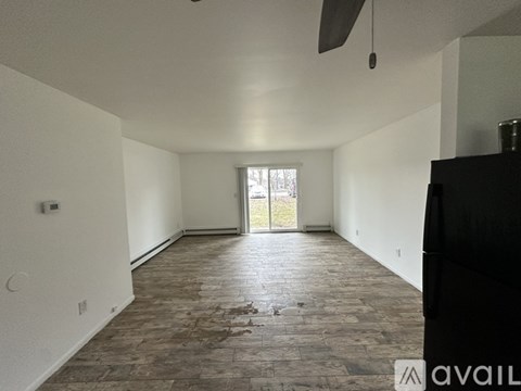 A spacious room with a fan and a door leading outside.