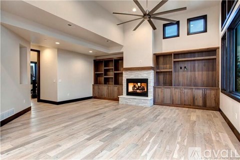 A spacious living room with a fireplace and built-in shelves.